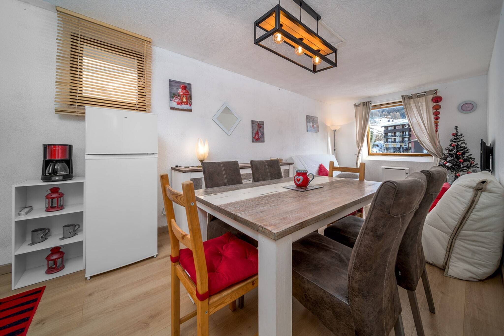 Un espace de vie compact comprenant un coin repas, une kitchenette et un coin salon confortable.