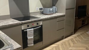 A modern kitchen with a built-in oven, a stovetop, and a toaster on the countertop. - Apartment - Parking - Pet Friendly - City Centre (Leeds)