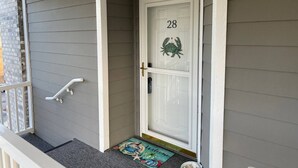 A gray house with a white door marked with the number 28 and a crab decoration. - 3-bedroom condo in superb Little River with AC, WiFi (Little River)