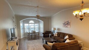 A living room with a dining area, a ceiling fan, and a chandelier. - 3-bedroom condo in superb Little River with AC, WiFi (Little River)