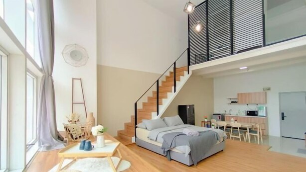 Un apartamento moderno con habitación tipo loft, una escalera, una cocina y zona de comedor.