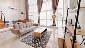 Una sala de estar moderna con sofá, mesa de centro y un ventanal con cortinas.