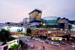 A multi-story hotel with a prominent glass facade, a large sign reading 'BANDAR UTAMA,' and a busy street in front. - Empire City Signature Duplex Suites (Petaling District)