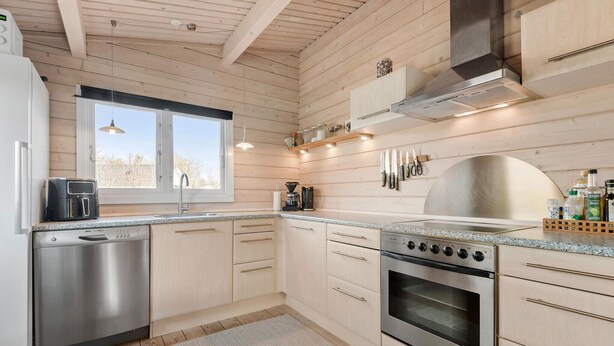 Une cuisine moderne avec des murs en bois, des appareils électroménagers en acier inoxydable et une grande fenêtre.