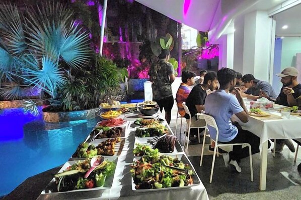 A dining area with multiple tables and a variety of dishes.