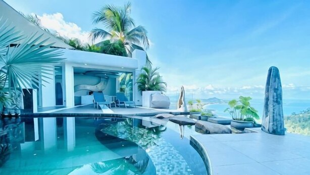 A modern infinity pool with a view of the ocean, a lounge area with seating, and tropical plants. - Samui Sky Pool Villa (Koh Samui)