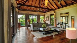 A spacious living area with a high ceiling, a sofa set, a coffee table, and a lamp. - Pulung Villa (Bali)