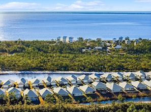 A coastal resort with multiple-story houses, a marina, and a view of the ocean.