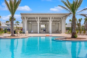 A swimming pool with lounge chairs and a covered pavilion.