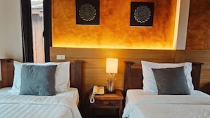 A hotel room with two beds, a bedside table with a lamp, and decorative wall art. - R1 Resort Rajapruek Chiangmai (Hang Dong)