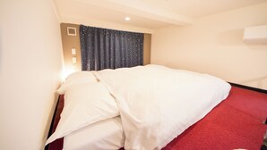 A hotel room with a bed, red carpet, white walls, and a window with a curtain. - Apartment Sanjo (Nara City)