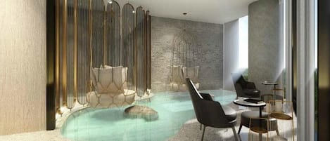 Un espace piscine intérieur moderne, doté de sièges et d’un mur décoratif.