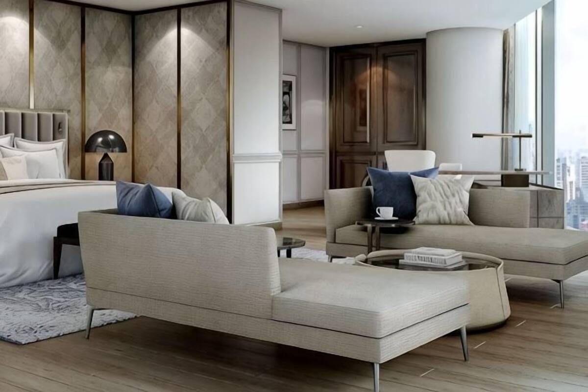 Quarto de hotel moderno com uma cama grande, um sofá, uma mesa de centro e vista para a cidade.