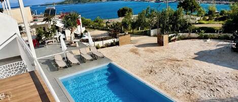 Una piscina al aire libre de temporada, sombrillas