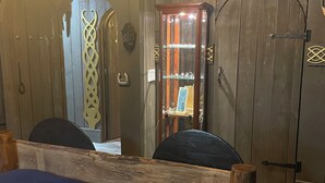 A room with a wooden bed frame, a cabinet with glass doors, and a chandelier. - Kings Court (Dalton)