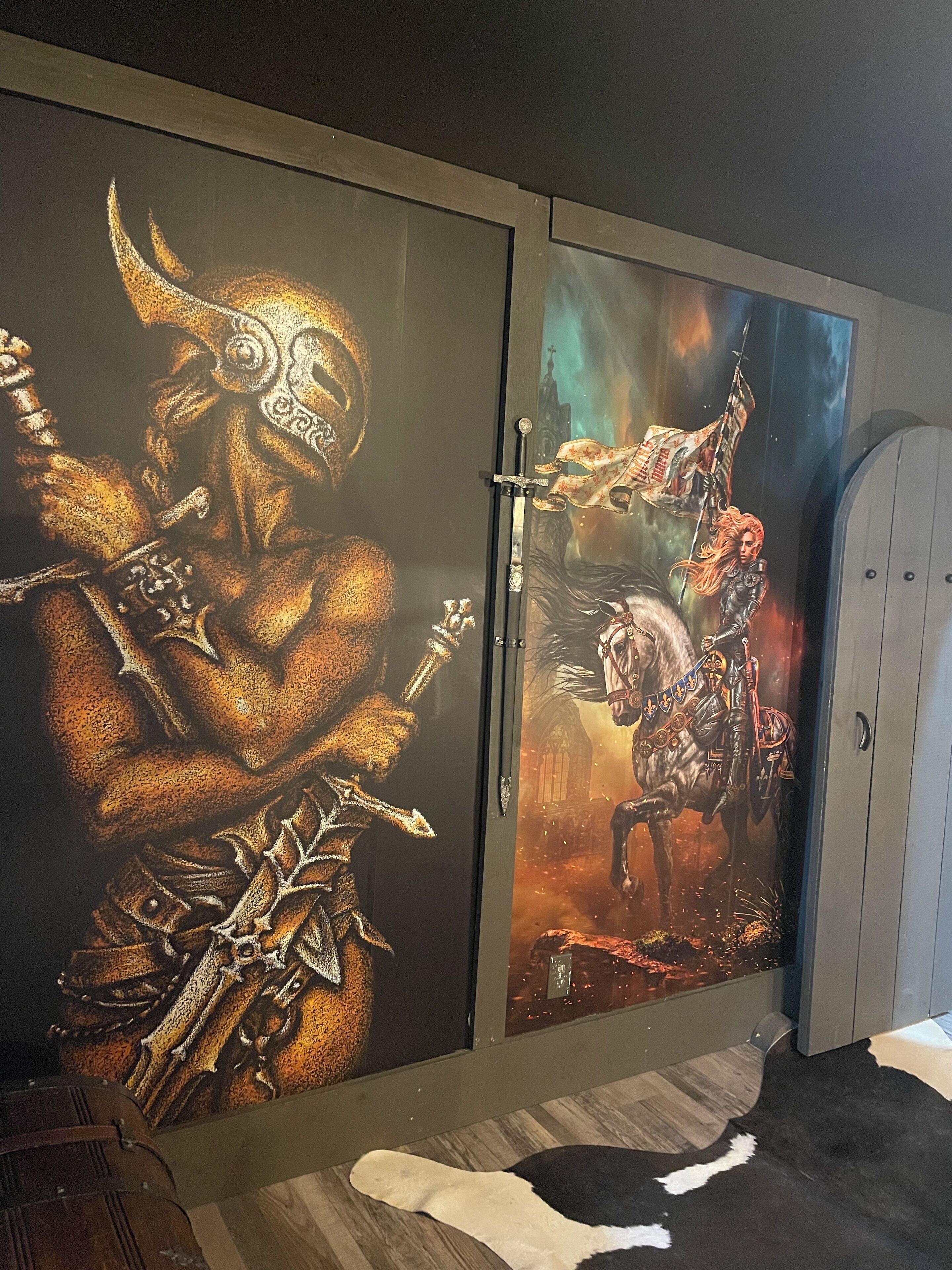 A room with a large wall mural depicting a warrior and a horse.