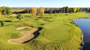A golf course with a water body, sand traps, and a clear sky. - King Bed Mtn Escape Free Parking 1hr to Banff (Calgary)