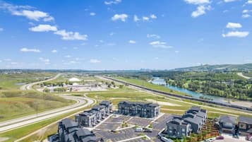 Un quartier résidentiel avec des immeubles d’appartements modernes, un parking et une rivière en arrière-plan.