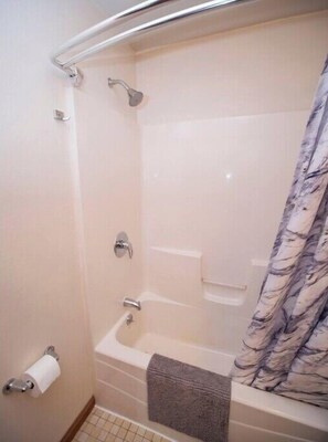 A bathroom with a shower, toilet, and a towel rack. - Close Counts when you're playing any season. (Wisconsin Dells)