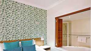 A hotel room with a bed, a nightstand, a lamp, a bathroom with a shower and a bathtub, and a large mirror. - Mantra on the Inlet Port Douglas (Port Douglas)