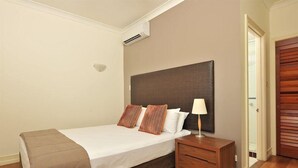 A bedroom with a bed, bedside table, and a wardrobe. - Mantra on the Inlet Port Douglas (Port Douglas)