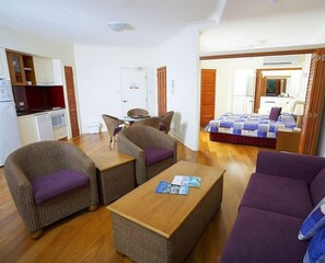 A compact room with a kitchenette, a dining area, a bed, and a seating area with a table. - Mantra on the Inlet Port Douglas (Port Douglas)