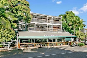 A two-story building with a covered outdoor seating area and a sign that reads 'On The Veldt.'