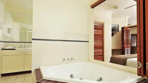 A bathroom with a large bathtub, a sink, and a mirror. - Mantra on the Inlet Port Douglas (Port Douglas)
