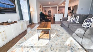 A modern living room with a wooden coffee table, grey sofa with floral cushions, and a patterned rug. - Cornerstone Retreat in Arlington (Arlington)