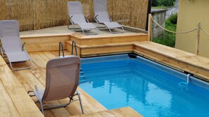 A poolside area with wooden deck, lounge chairs, and a clear blue pool. - Awesome home in Zuta Lokva with WiFi (Zuta Lokva)