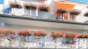 En flervåningsbyggnad med balkonger som är dekorerade med blomlådor och räcken.
