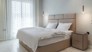 A modern bedroom with a large bed, a nightstand, and a window with sheer curtains. - Fancy hosting (Riyadh)