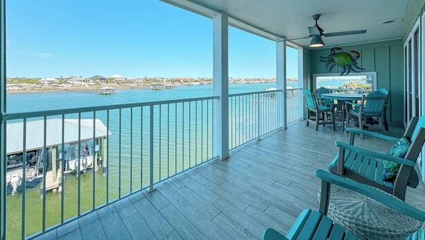Un balcon spacieux offrant une vue sur l’eau et les bâtiments situés au loin.