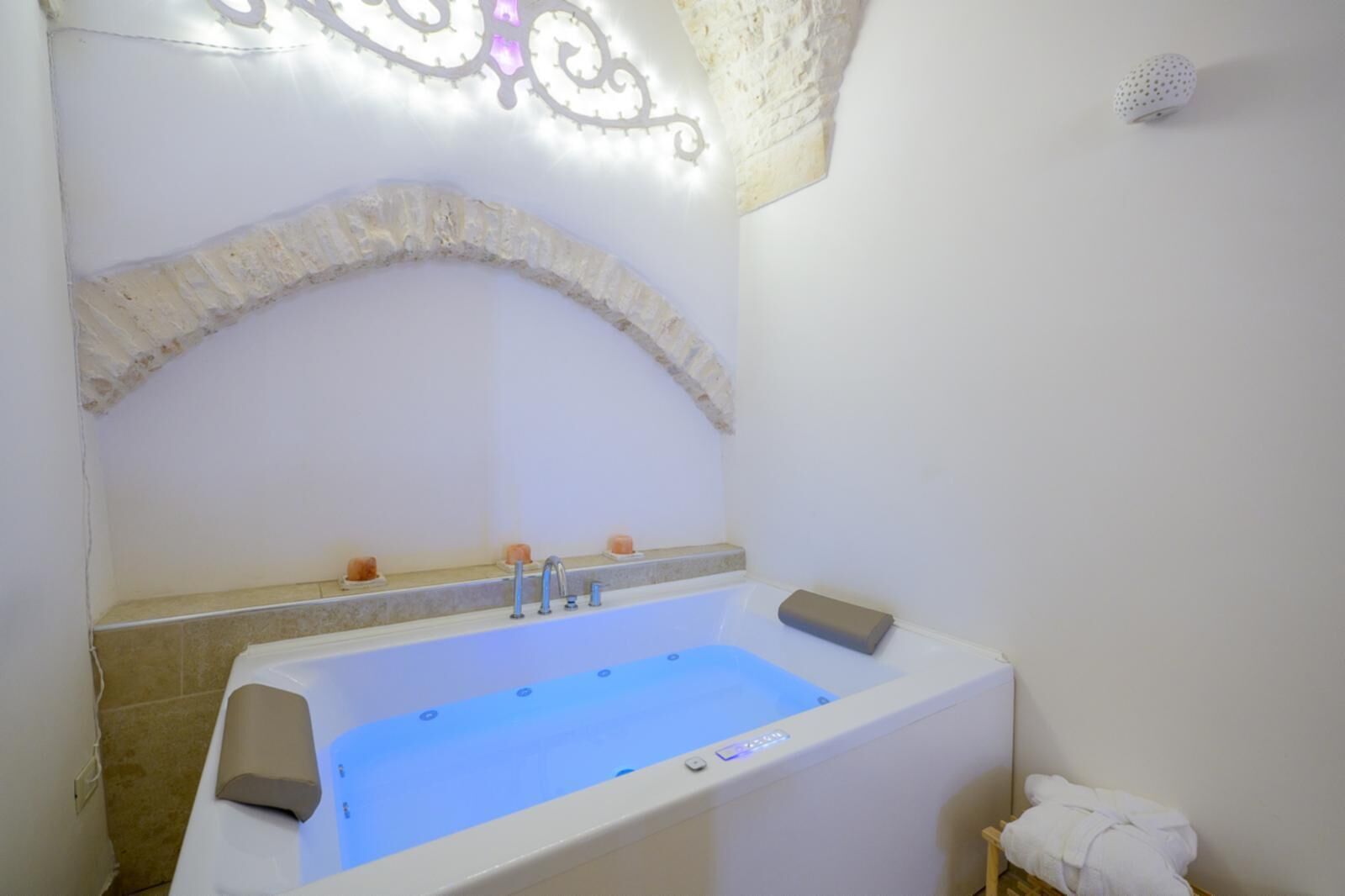 A modern bathroom with a freestanding bathtub, a built-in bench, and a towel rack.