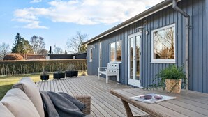 A deck with a sofa and a table, a bench, and a potted plant. - 3 bedroom awesome home in Odder (Odder)