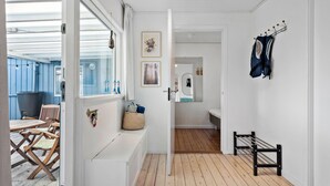 A hallway with a wooden bench, a coat rack, and a mirror. - 3 bedroom awesome home in Odder (Odder)
