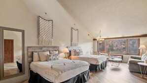 A spacious bedroom with two beds, a large mirror, and a view of the outdoors through a window. - Luxurious studio condo in lovely Durango, Colorado.  Stay and Play year round. (Durango)