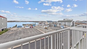 Un estacionamiento con vista a un puerto deportivo y edificios al fondo.