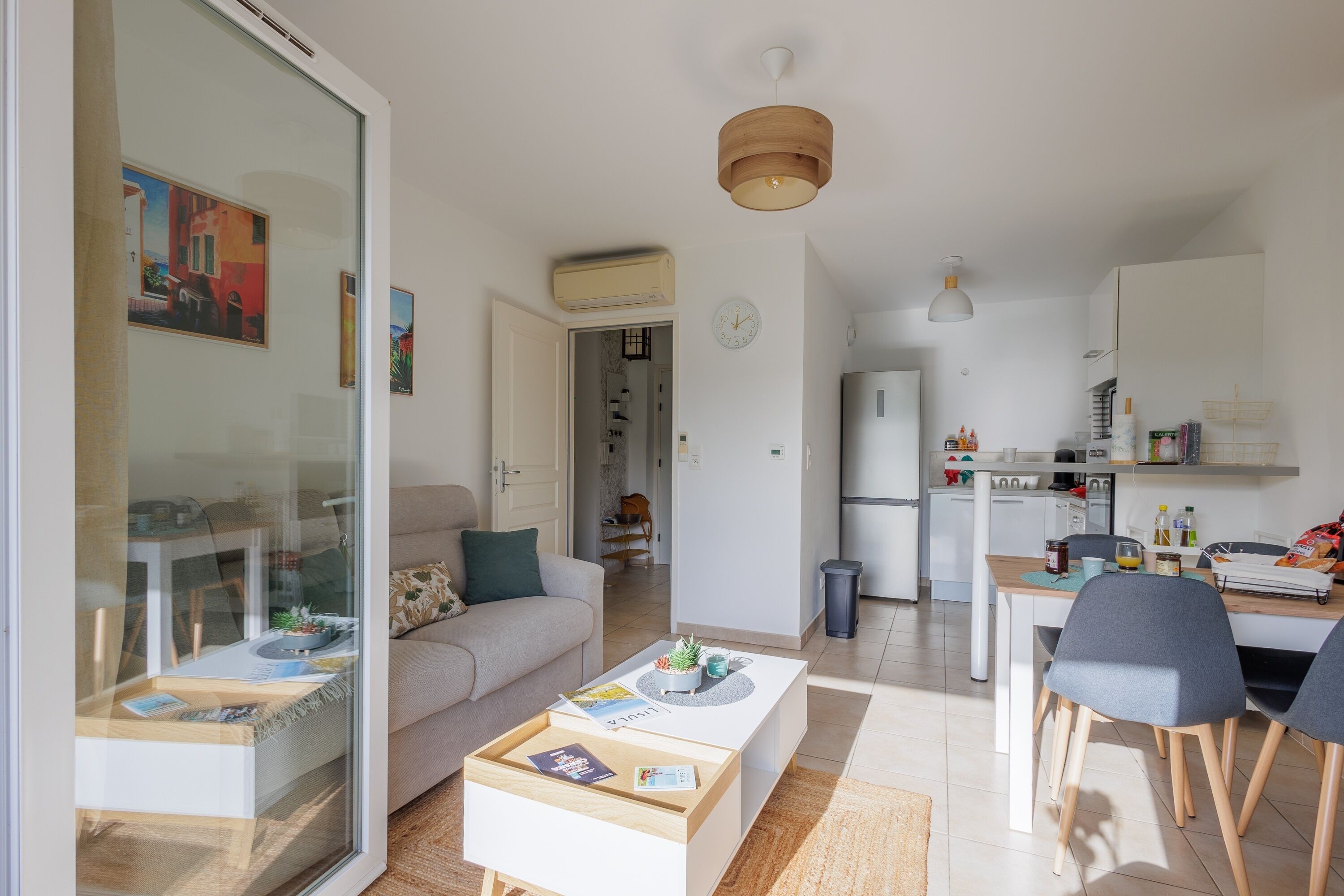 A modern living room with a sofa, coffee table, and dining area.