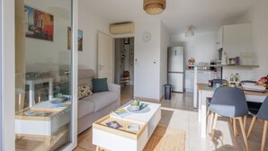 Un salon moderne avec un canapé, une table basse et un coin repas.