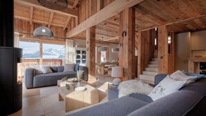 Un interior acogedor de madera con chimenea, sofás y comedor.