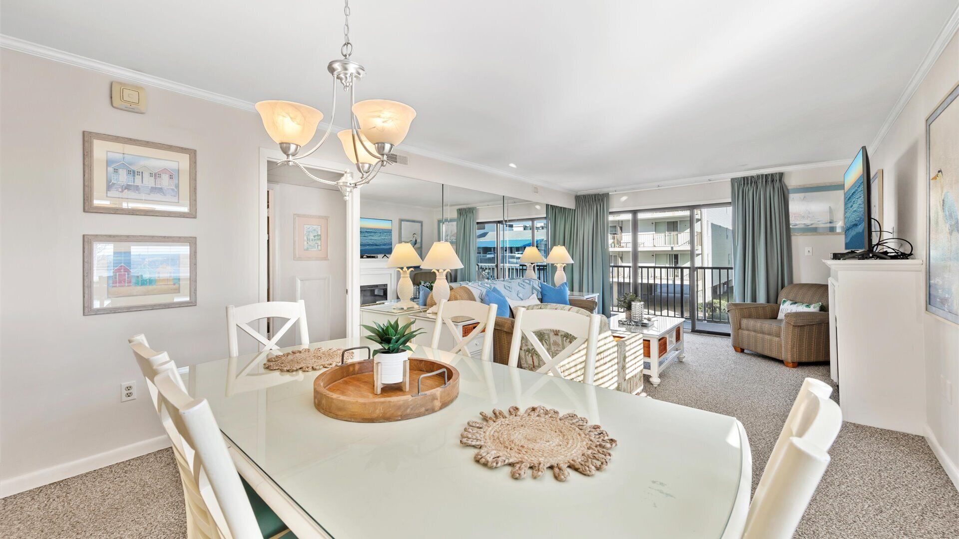 Un salon moderne avec un coin repas, de grandes fenêtres et une vue sur la mer.