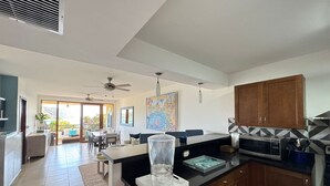 A modern kitchen with a black countertop, wooden cabinets, and a large window. - San Juan del Sur most exclusive condo! (San Juan del Sur)