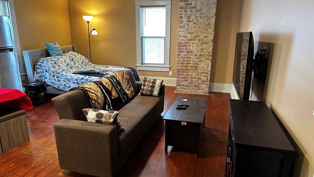 A cozy living room with a sofa, a coffee table, and a TV stand. - Apt 2B Lake Bomoseen Inn “The Dog” with boat slip (Castleton)