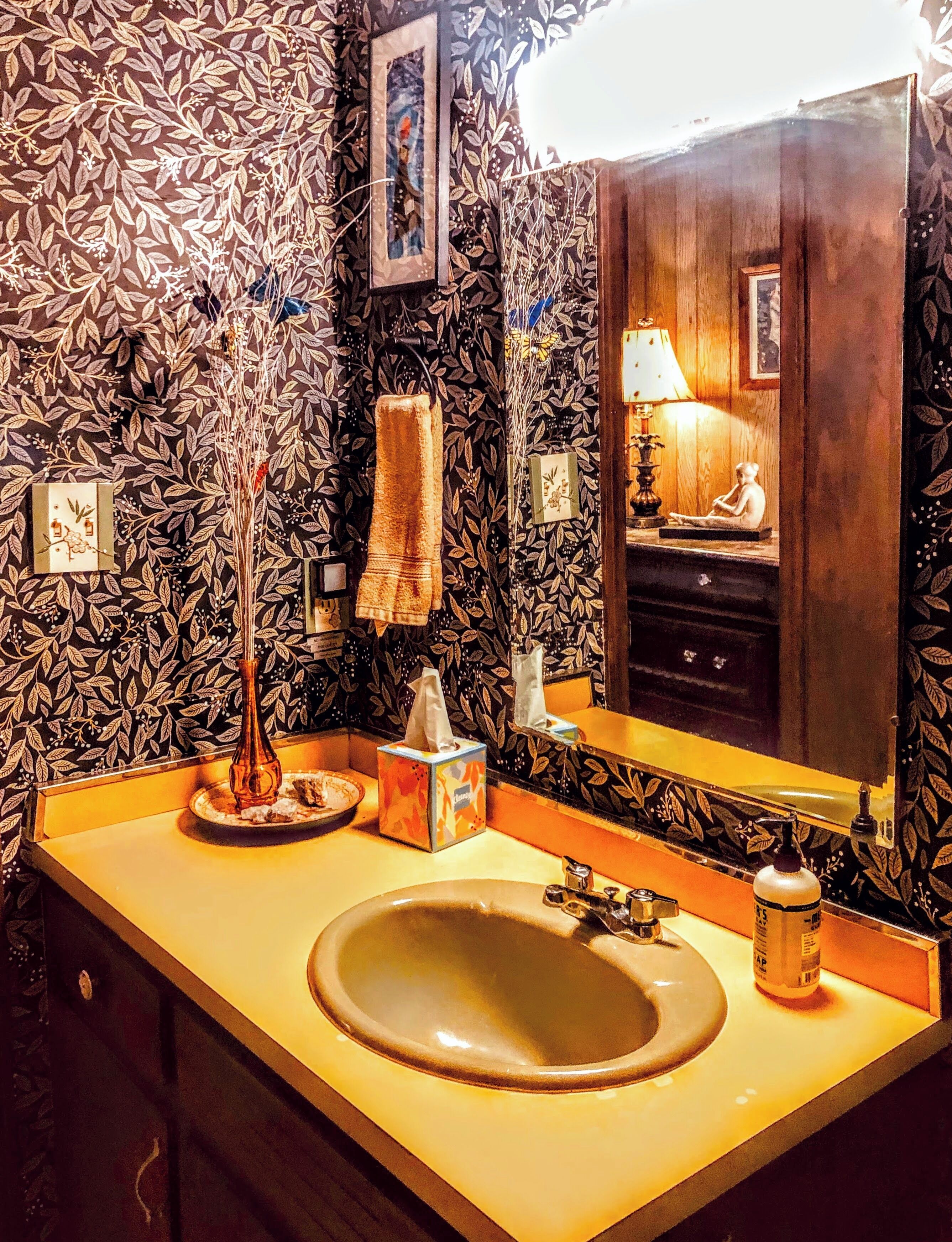 A bathroom with a large sink, a mirror, and a towel rack.