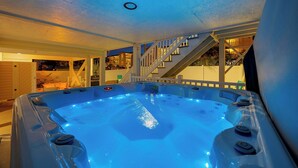 Un jacuzzi con cubierta de madera y escaleras que conducen a un balcón.