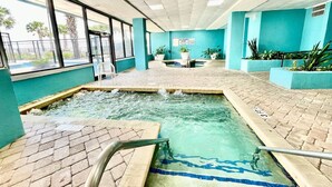 An indoor pool area with tiled flooring, a central water feature, and potted plants. - King bed studio amenities 812 (Myrtle Beach)