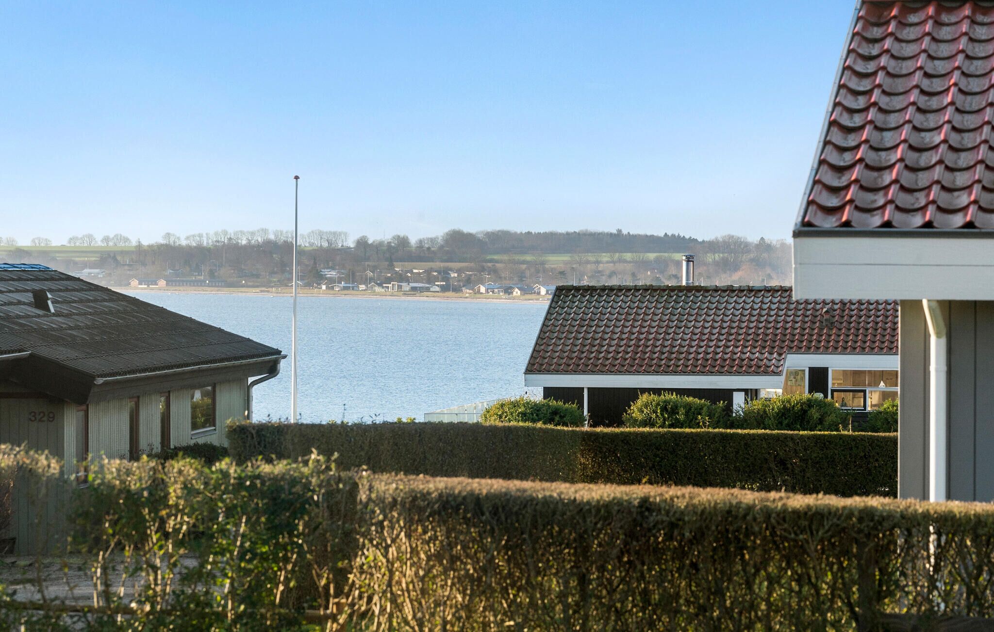 Blick auf die Küste mit einem Gebäude mit Ziegeldach und blauem Himmel.
