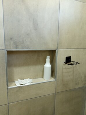 Een douche, handdoeken, zeep, toiletpapier