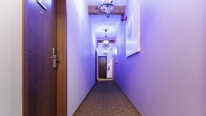 Ein Flur mit gemustertem Teppich, Holztüren und einem Chandelier.